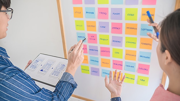 Burza mózgów projektanta stron internetowych dla planu strategicznego. Kolorowe karteczki z rzeczami do zrobienia na tablicy. Koncepcja doświadczenia użytkownika (UX).
