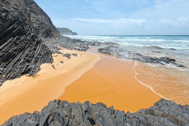 Burza na Oceanie Atlantyckim i plaża Castelejo z czarnymi łupkami klifowymi (Algarve, Portugalia).