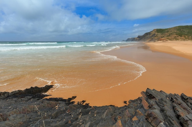 Burza na plaży Castelejo z czarnymi łupkami klifowymi (Algarve, Portugalia). Ludy nie do poznania.