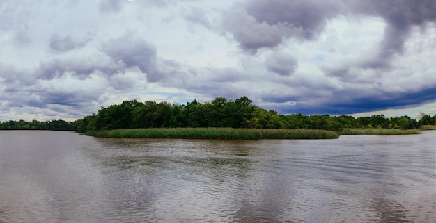 Burzowe chmury nad rzeką wiosną silny wiatr i chmury przechodzą nad rzeką mroczne dramaty