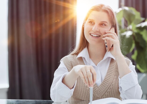 Businesswoman komunikacji korporacyjnej rozmawia przez telefon komórkowy w nowoczesnym biurze