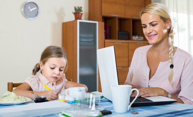 businesswoman przeglądania Internetu w domu, córka rysunek ołówkiem