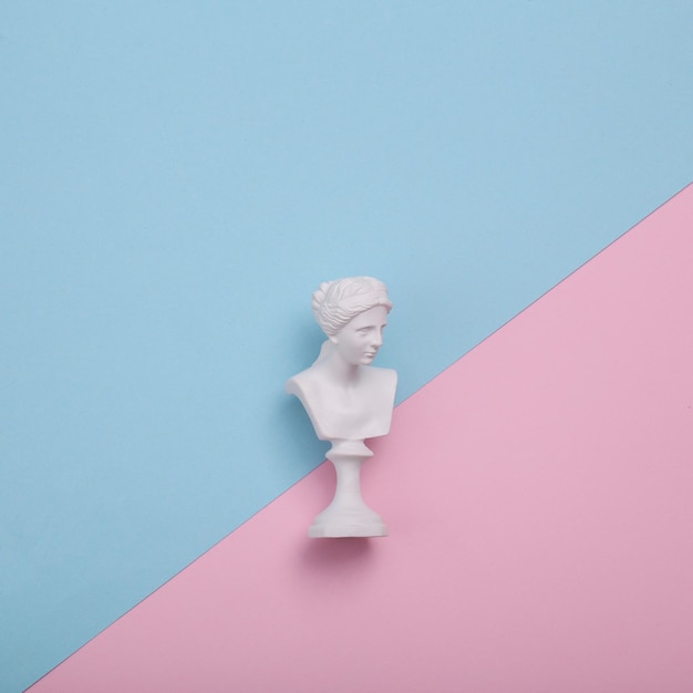 Bust Wenus na różowym i niebieskim tle Kreatywny układ Minimalna martwa natura Płaski widok górny