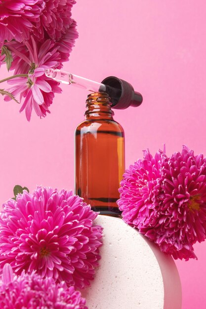 Butelka kosmetyczna z serum na podium z ekstraktami kwiatowymi Kosmetyk do pielęgnacji skóry Serum olejowe z kwasem hialuronowym z kolagenem i peptydami