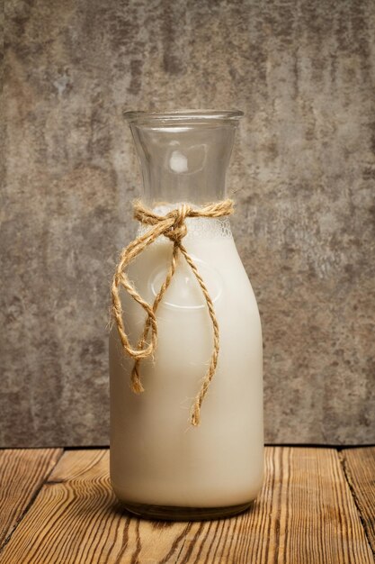 Butelka mleka migdałowego na drewnianym stole