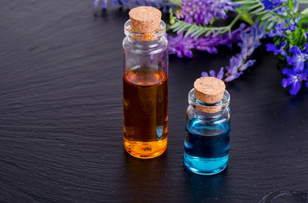 Zdjęcie butelka niebieskiego olejku ze świeżych kwiatów.