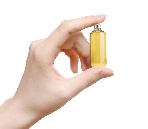 Butelka olejku eterycznego w ręce kobiety na białym tle