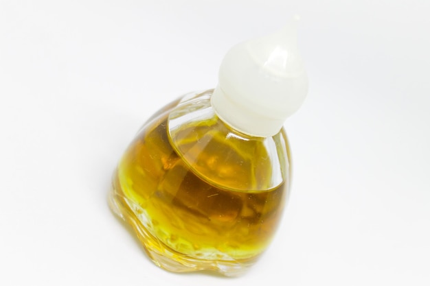 Zdjęcie butelka oliwy z oliwek jest pokazana na białym tle.