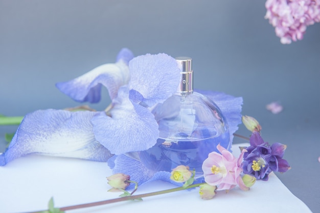 Butelka perfum fioletowe koło z kwiatami.
