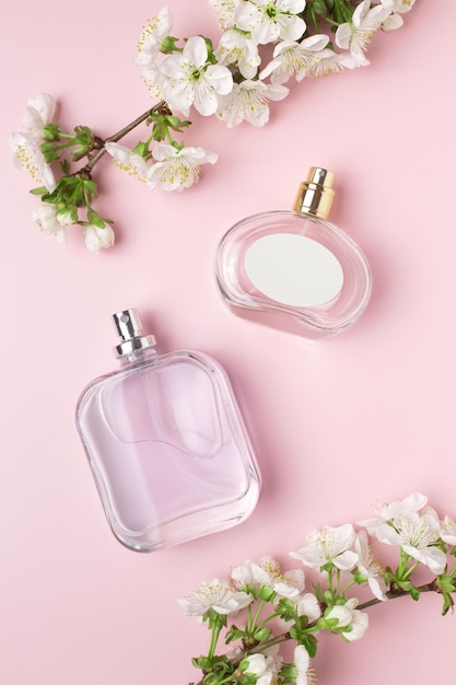 Butelka perfum i gałąź kwitnąca wiśnia Koncepcja drogich perfum i kosmetyków Kwiatowy zapach dla kobiet Perfumy w sprayu Nowoczesna luksusowa damska perfuma toaletowa