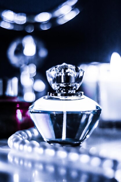 Butelka perfum i zapach vintage na glamour toaletce w nocy biżuteria z pereł i wody perfumowane jako prezent świąteczny prezent luksusowej marki kosmetycznej