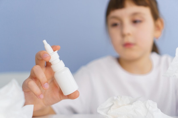 Butelka sprayu do nosa w dłoni dziewczynki Leczenie alergicznego wirusowego i bakteryjnego nieżytu nosa i zapalenia zatok