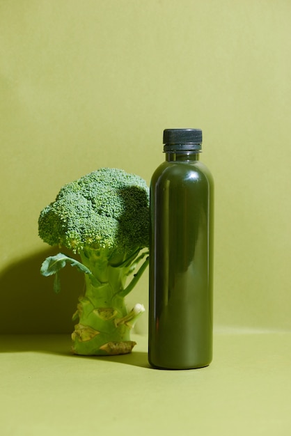Butelka świeżego soku z brokułów na stole. Zdrowy napój.