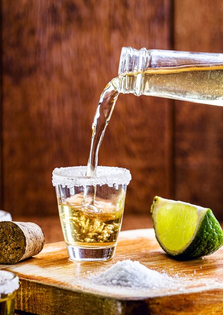 Butelka tequili napełniająca szklankę napoju Typowy meksykański napój serwowany