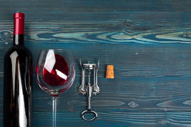 Butelka wina, korek i korkociąg na drewnianym stole