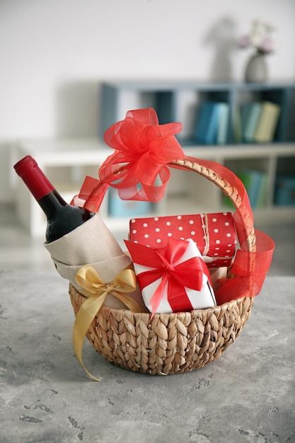 Butelka wina z pudełkami prezentowymi w wiklinowym koszu na rozmytym tle