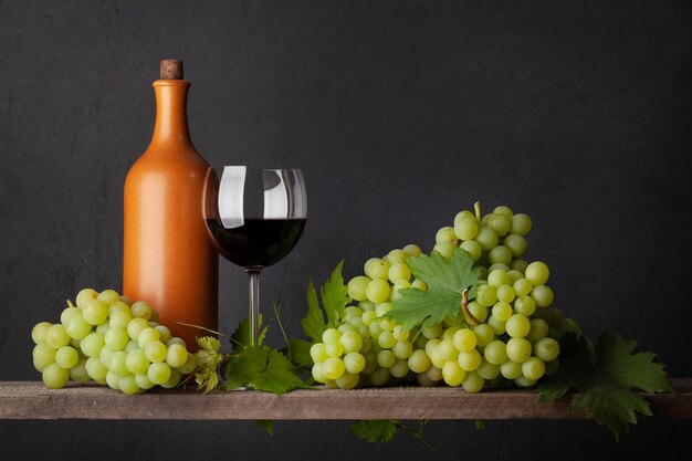 Butelka z białych winogron i kieliszek do czerwonego wina