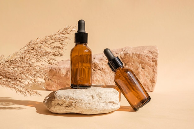 Butelka z ciemnego bursztynu stojąca na kamieniu Naturalna pielęgnacja skóry Projekt kosmetyków SPA MockUp