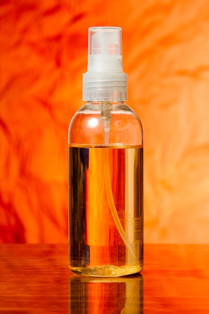 Butelka z rozpylaczem oleju do ciała leży na stole