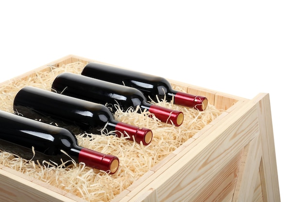 Butelki wina w otwartej drewnianej skrzyni na białym tle
