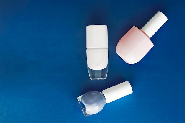 Butelki z lakierem do paznokci na ciemnoniebieskim tle marki kosmetycznej