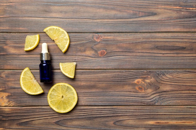 Butelki z olejkiem eterycznym z owoców cytryny na drewnianym tle medycyna alternatywna widok z góry z miejscem na kopię