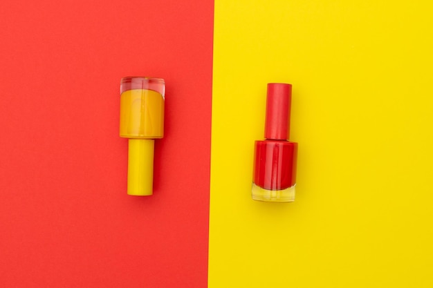 Butelki żółtych i czerwonych lakierów do paznokci