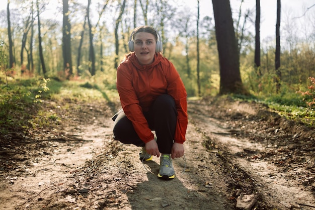 Buty do biegania na świeżym powietrzu i kobieta sportowa rozpoczynają trening cardio w leśnym sportowcu gotowym do ćwiczeń