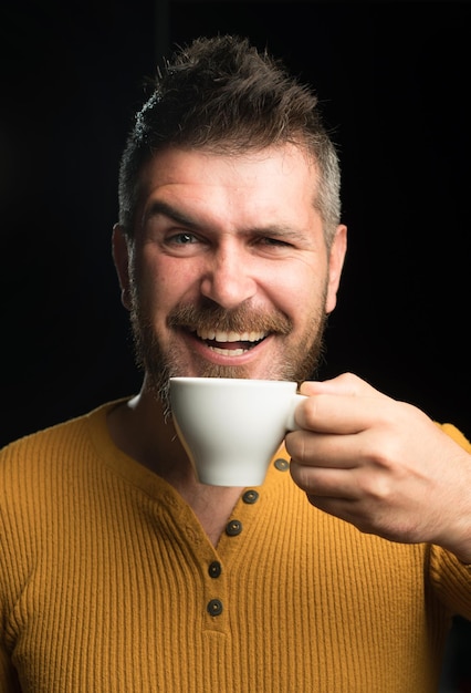 Bycie w nastroju do kawy szczęśliwy hipster pijący kawę rano brodaty człowiek uśmiechający się z kawą