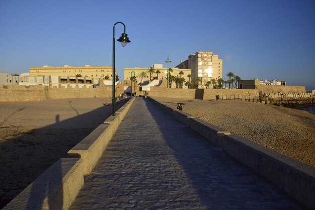 Cadiz Hiszpania 06 listopada 2019 La Caleta z zamkiem San Sebastian Wyspa La Caleta w tle Widok z promenady Paseo Fernando Quinones