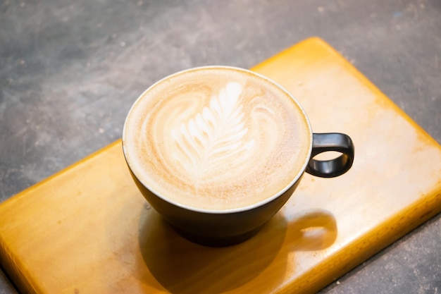 Cafe latte art serwowane w filiżance izolowanej na ciemnoszarym tle widok z góry gorącej kawy