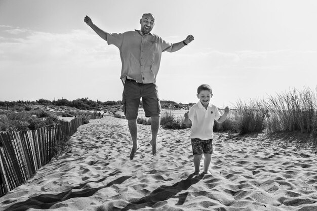 Zdjęcie cała długość przyjaciół stojących na plaży przeciwko niebu