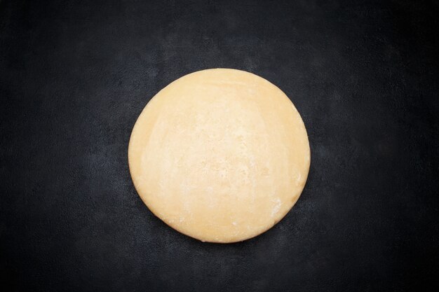Cała okrągła główka parmezanu lub sera parmigiano na betonowej przestrzeni