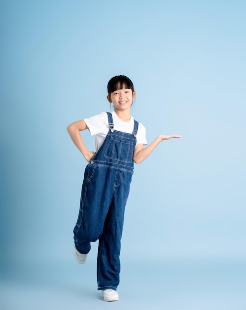 Zdjęcie całe ciało azjatyckiej dziewczyny pozującej na niebieskim tle