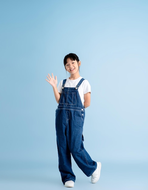 Zdjęcie całe ciało azjatyckiej dziewczyny pozującej na niebieskim tle