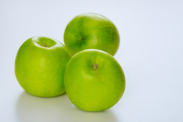 Całe zielone jabłka i na białym tle. Wyprodukuj produkt.