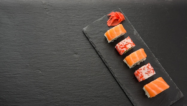 California Sushi Z Czerwonym Kawiorem Tobiko I Plasterkami Sushi Philadelphia Na Czarnej Tablicy łupkowej, Widok Z Góry