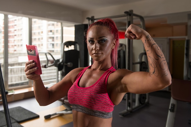 Całkiem mieszana rasa kobieta robi selfie w siłowni w centrum fitness w tle