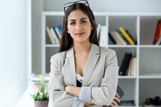 Całkiem młoda businesswoman spojrzenie na aparat fotograficzny w biurze.