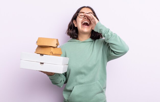 Całkiem młoda kobieta czuje się szczęśliwa, krzycząc głośno z rękami przy ustach. koncepcja fast food na wynos