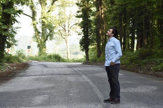 Całkowita długość człowieka stojącego na drodze w lesie