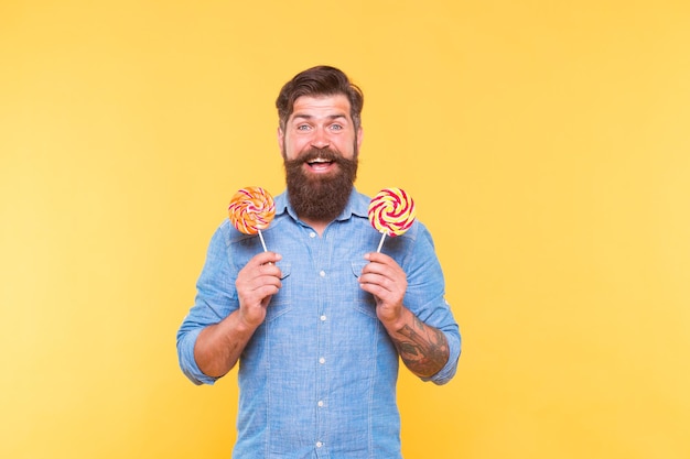 Candy man Szczęśliwy hipster trzyma lizaki na patykach Sklep ze słodyczami Fast food Przekąska i deser Twist, któremu nie możesz się oprzeć