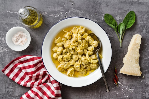 Cappelletti in brodo Włoskie danie na rodzinne wakacje na stole z parmezanem