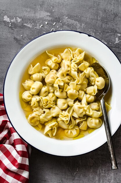 Cappelletti in brodo Włoskie danie na rodzinne wakacje na stole z parmezanem