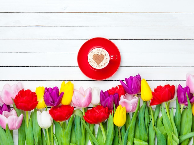 Cappuccino w pobliżu tulipanów
