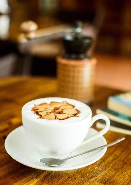 Zdjęcie cappuccino ze świeżą wodą z ziaren kawy i książkami na brązowym tle