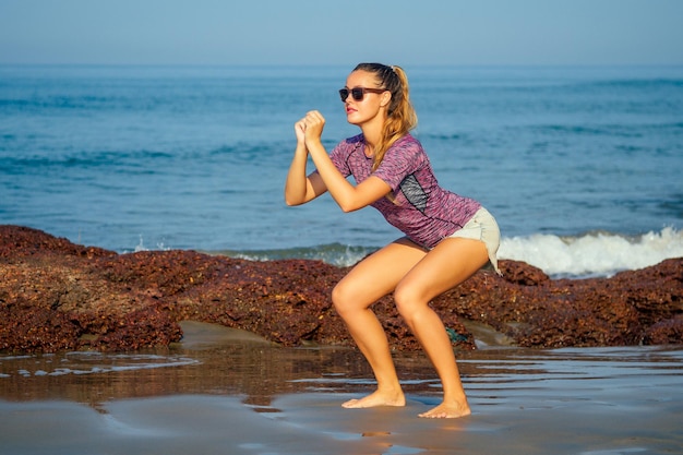 Cardio bieganie trening młodej pięknej kobiety rozgrzewka jogging na plaży fitness szczupłe ciało zdrowy tryb życia