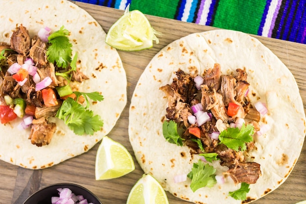 Carnitas szarpana wieprzowina z pico de gallo na tortilli z mąki.