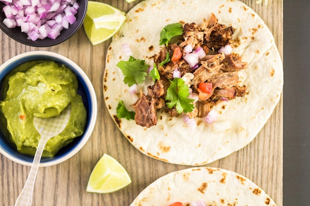 Carnitas szarpana wieprzowina z pico de gallo na tortilli z mąki.