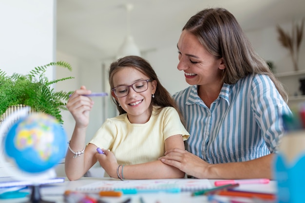 Caucasion kobieta patrząc dumna na swoją córkę podczas homeschooling i trochę malarstwa.